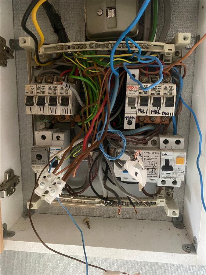 Old overcrowded fuse board before replacement