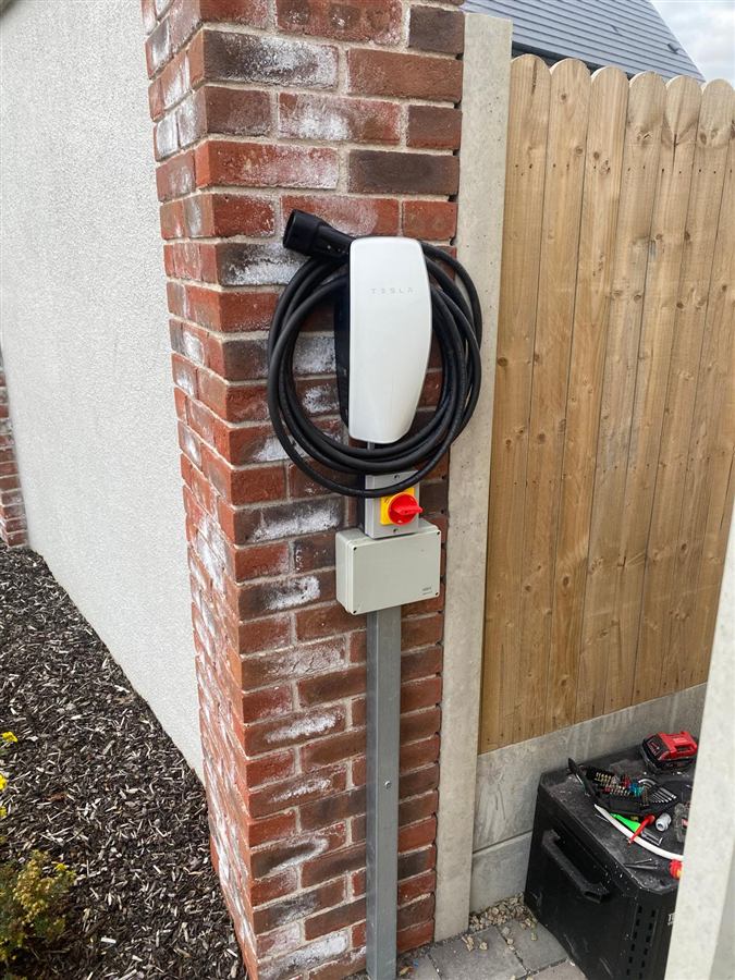 Tesla home EV charger installed on a brick pillar